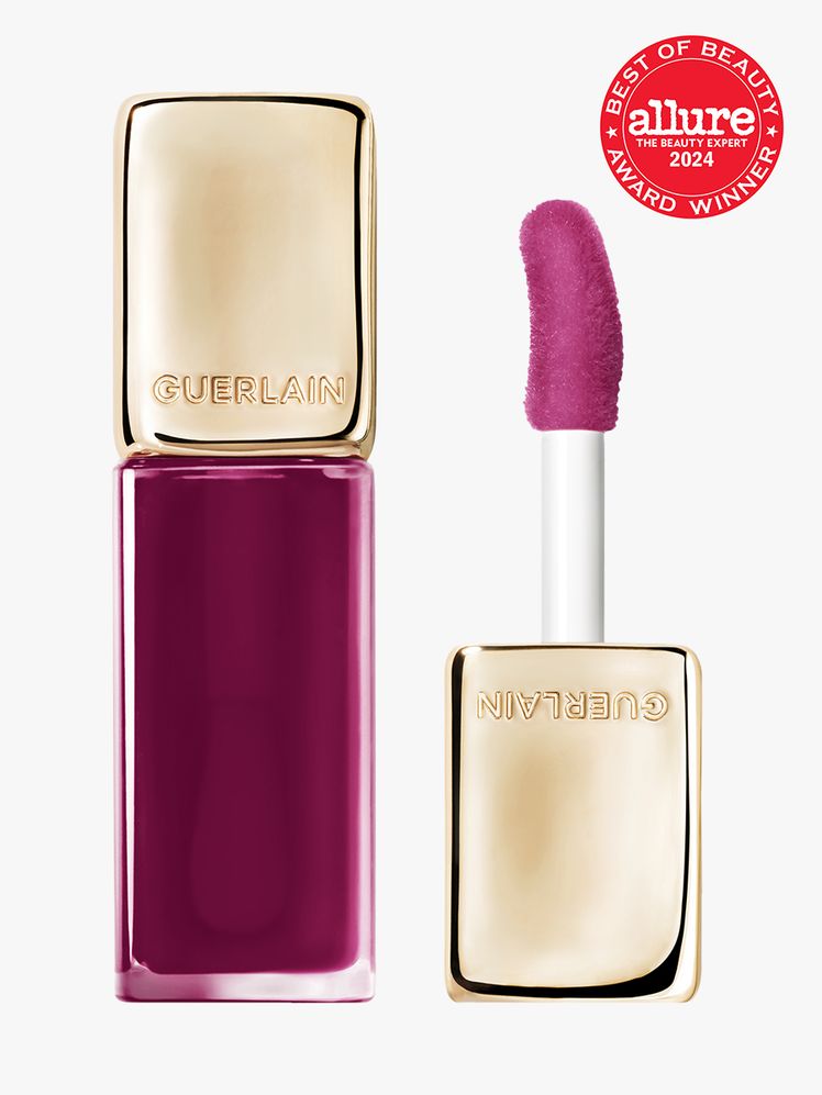 lip oil in branded clear tube with gold doe foot applicator cap on light gray background with red and white 2024 allure...