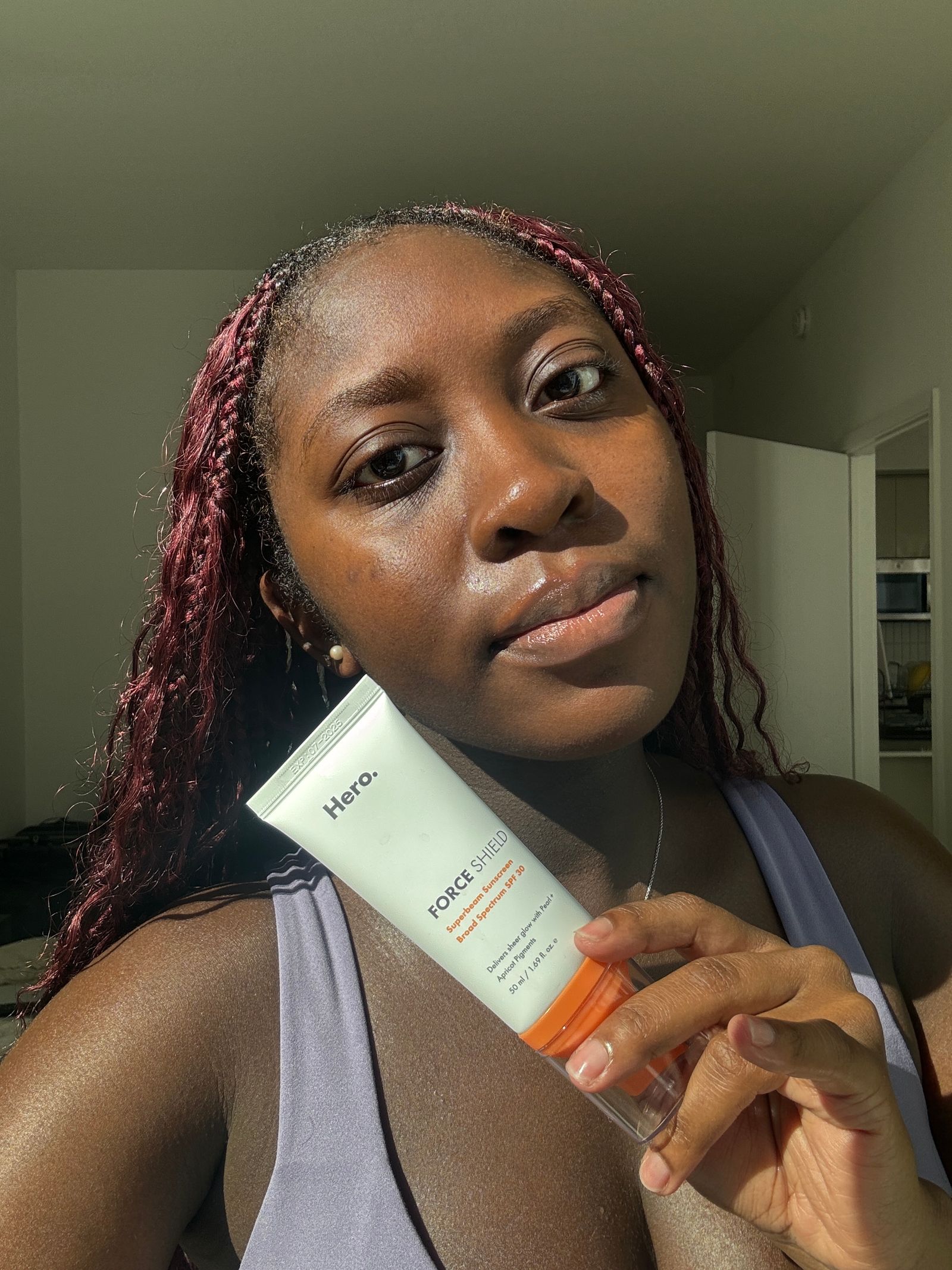 A selfie of Allure associate beauty editor Annie Blay before applying Hero Cosmetics Mineral Sunscreen on dark skin