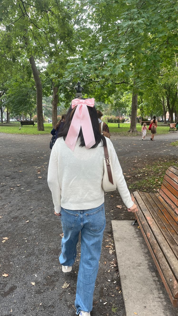 Image may contain Grass Nature Outdoors Park Plant Clothing Pants Person Sitting Accessories Bag and Handbag