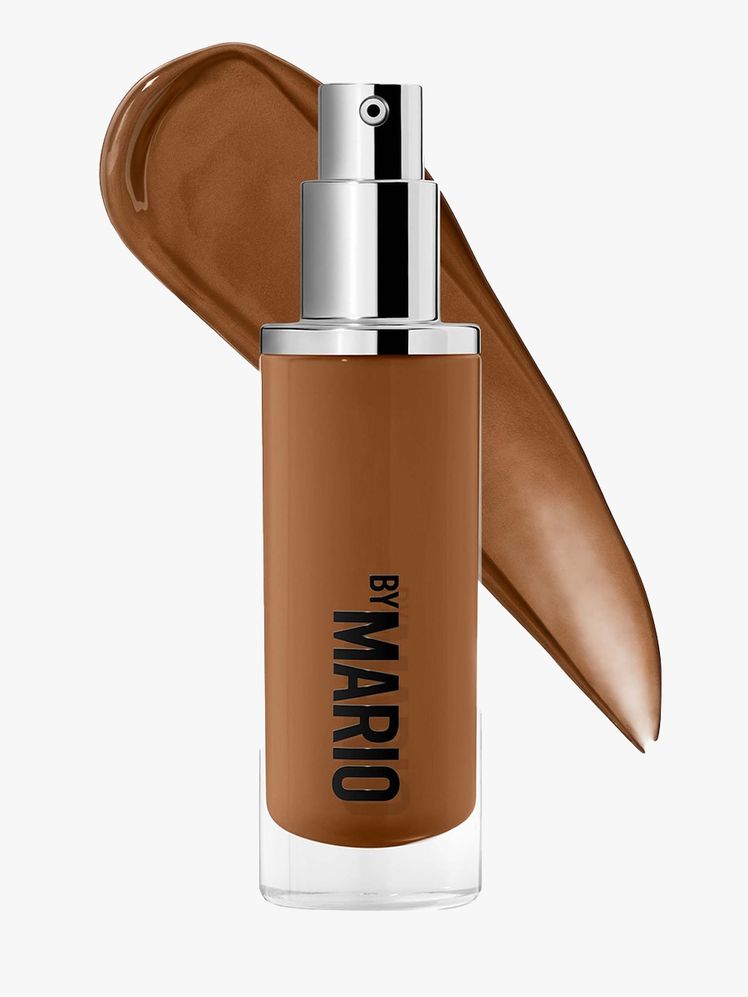 Makeup by Mario Surreal Skin Foundation bottle of foundation with a silver pump cap and a swatch behind it on light gray...