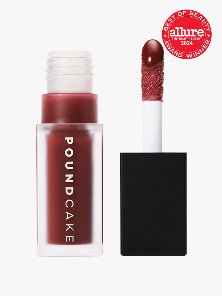 Pound Cake Cake Theory Lip Oil vial of dark red lip oil with cap and wand to the side on light gray background with red...