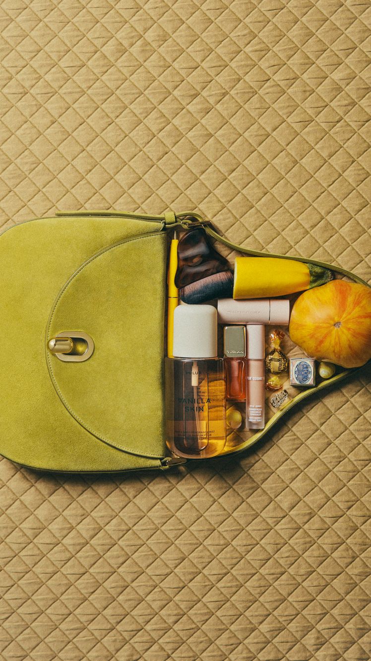 photo of green purse and beauty products on a quilted mustard yellow background