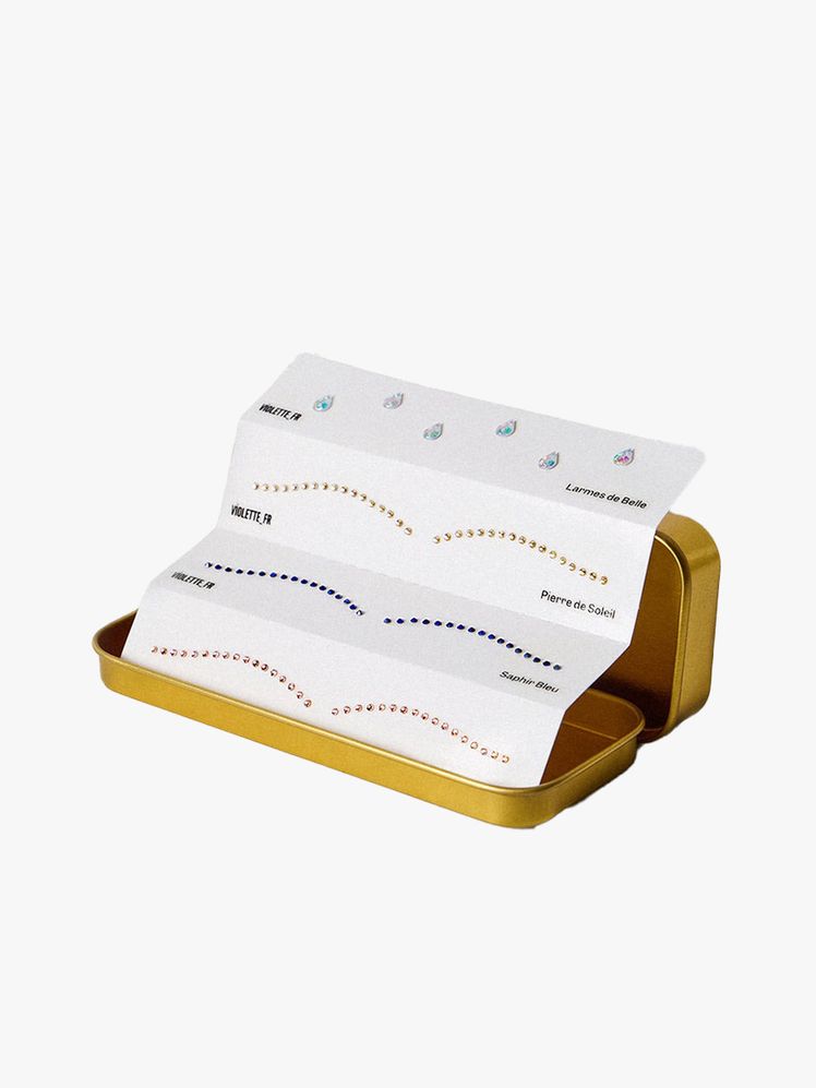 VioletteFr Eye Bijoux sheets of face gems in a gold case on light gray background