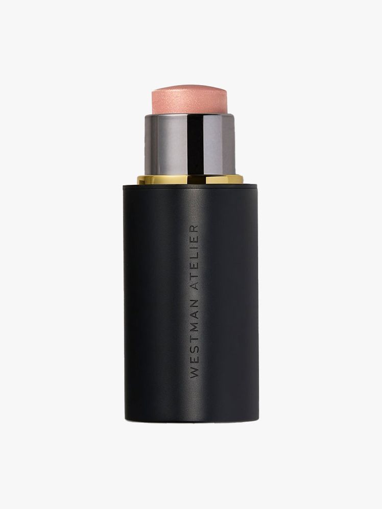 An open black tube of Westman Atelier Lit Up Highlight Stick in Nectar on a light gray background