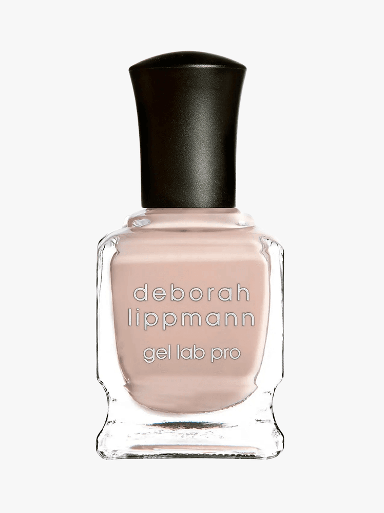 Deborah Lippmann light nude nail polish in a clear bottle with white lettering and a black cap on a grey background