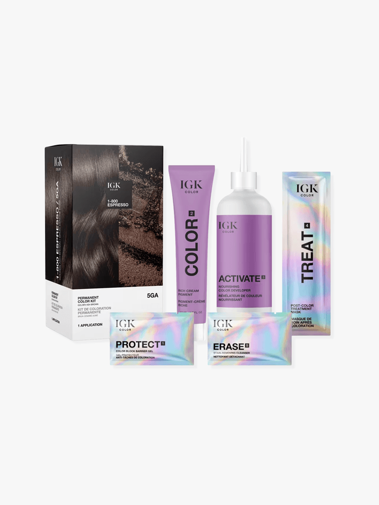 IGK permanent hair color kit including box, bottle, applicator, and satchets on a grey background