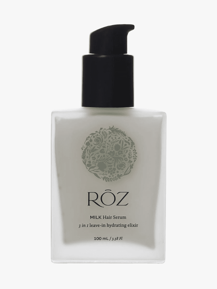 Milk Hair Serum in branded clear frosted bottle with black pump on light gray background