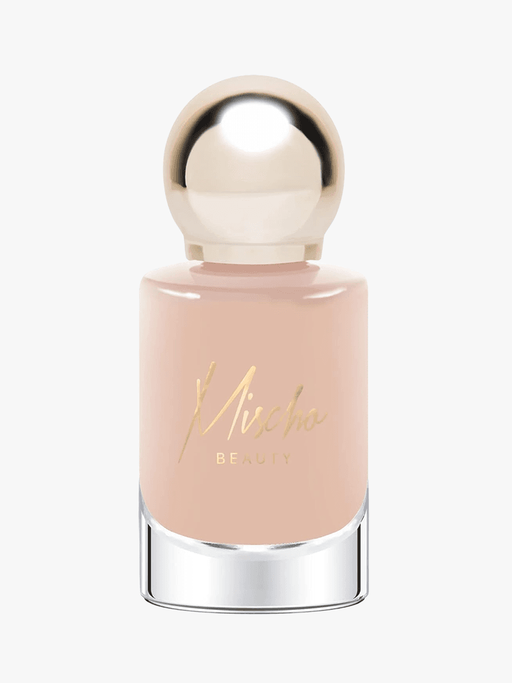 Mischo Beauty nude nail polish in clear bottle with metallic gold top and gold lettering on grey background