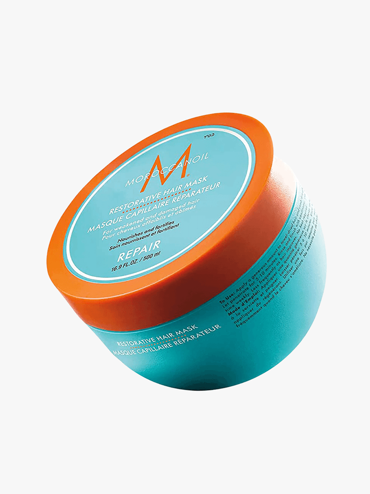 Moroccanoil restorative hair mask in teal tub with teal and orange cap on grey background