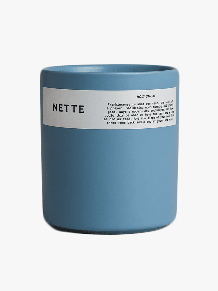 Nette Holy Smoke Scented Candle in branded component on a light gray background