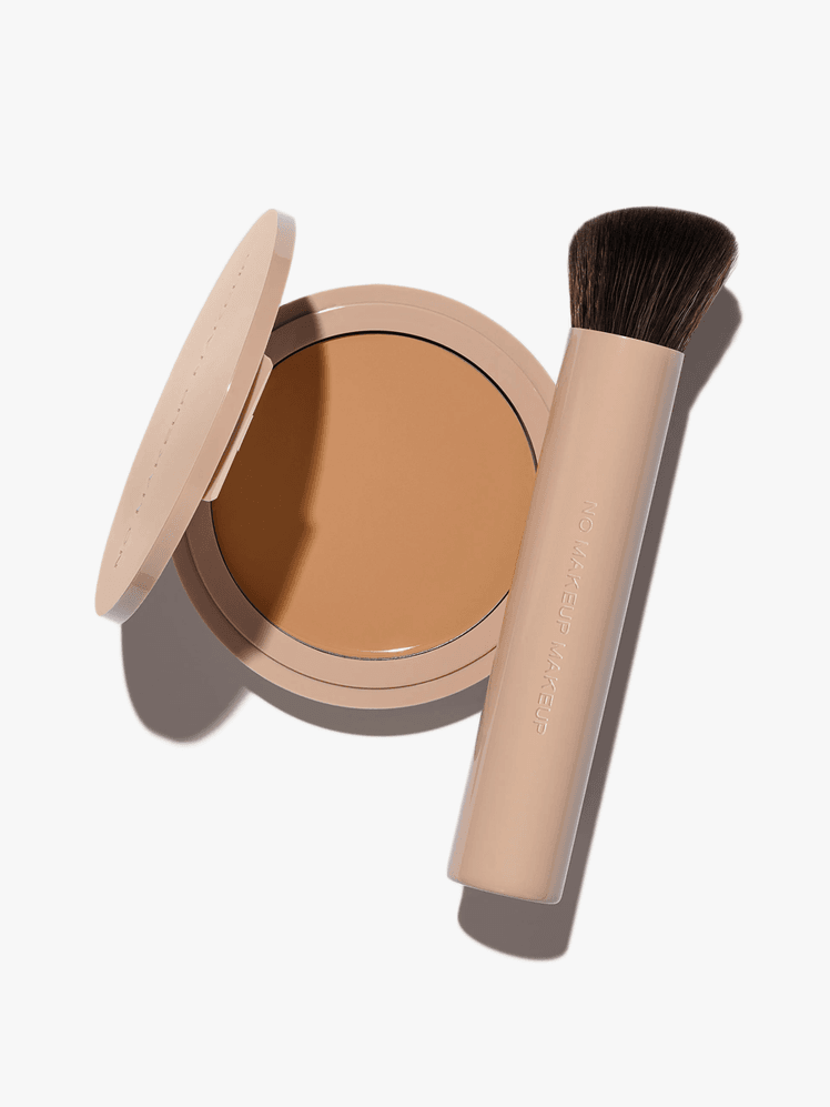 No Makeup Makeup Foundation and Brush in branded component on a light gray background