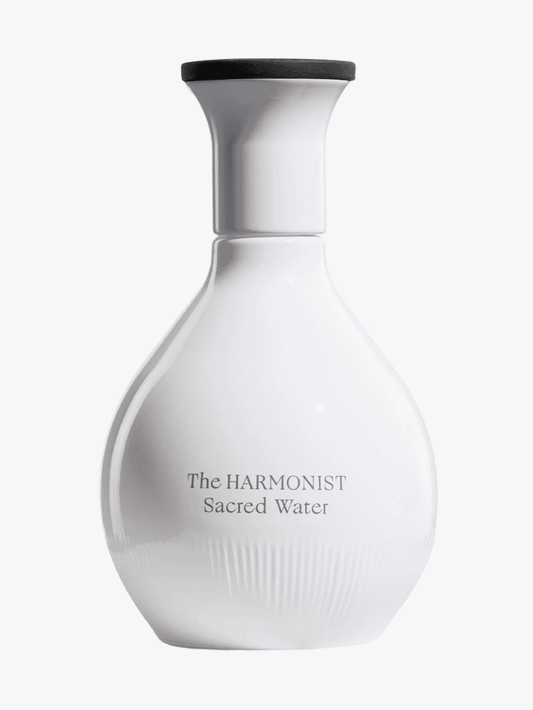 The Harmonist Sacred Water in white branded bottle component with black cap on a light gray background